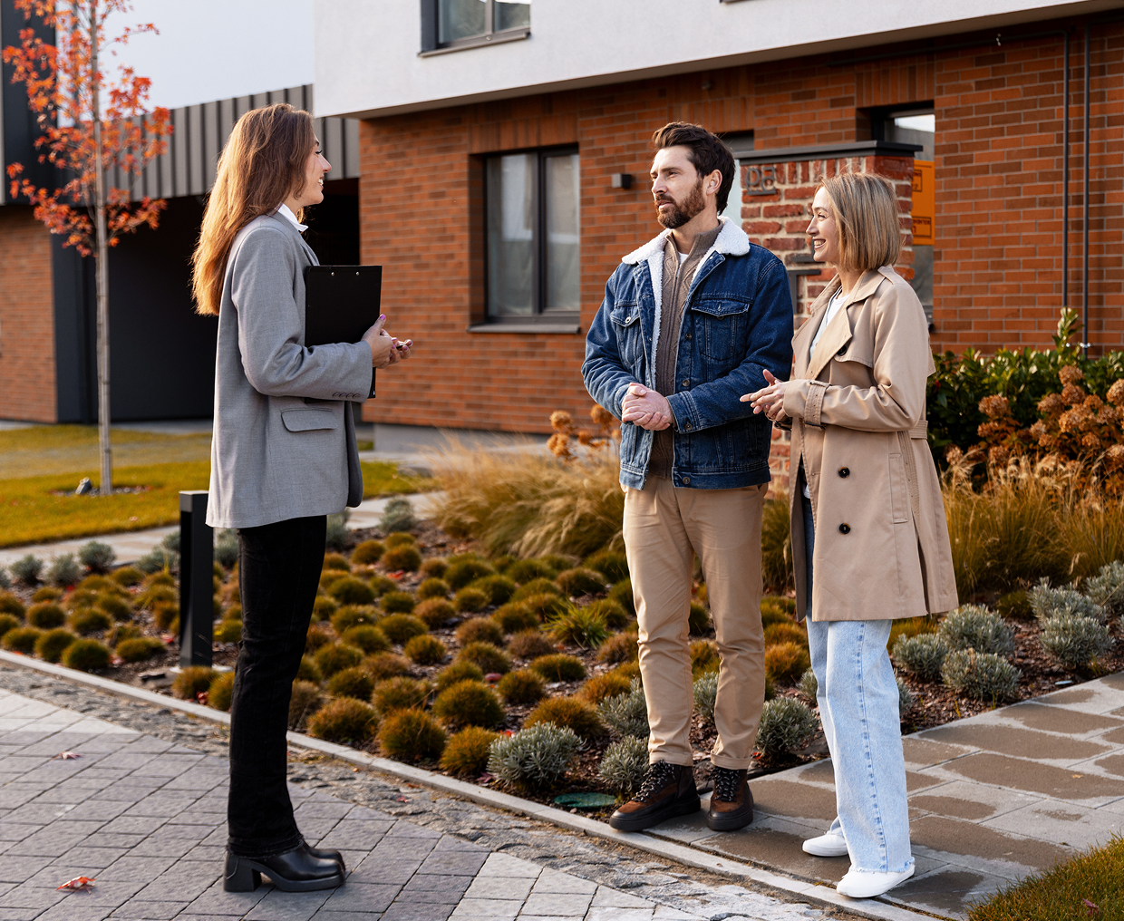 Real estate agent with couple outside house